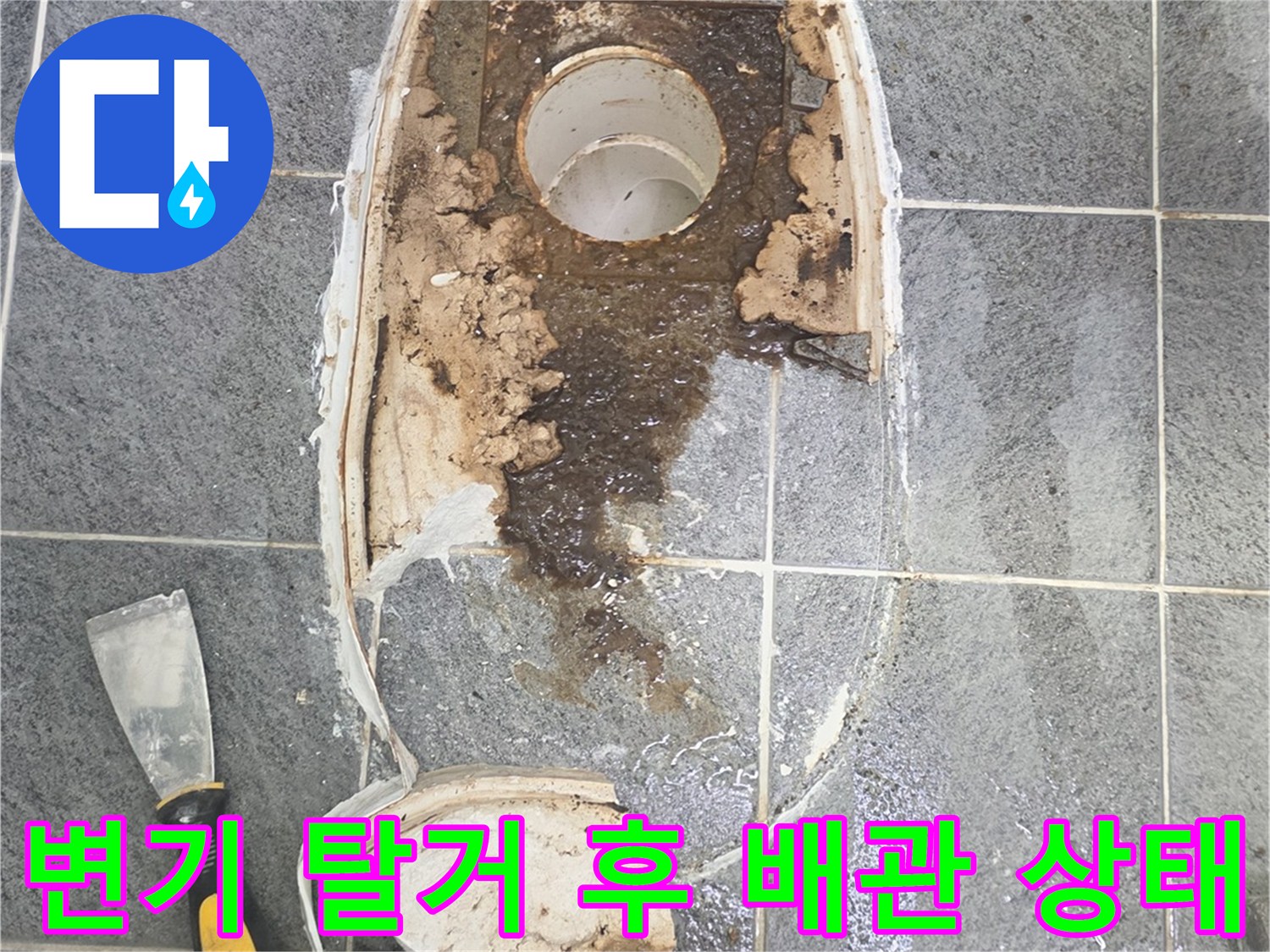 양변기를 제거한 후 드러난 오염된 배수관과 타일 바닥 모습입니다.