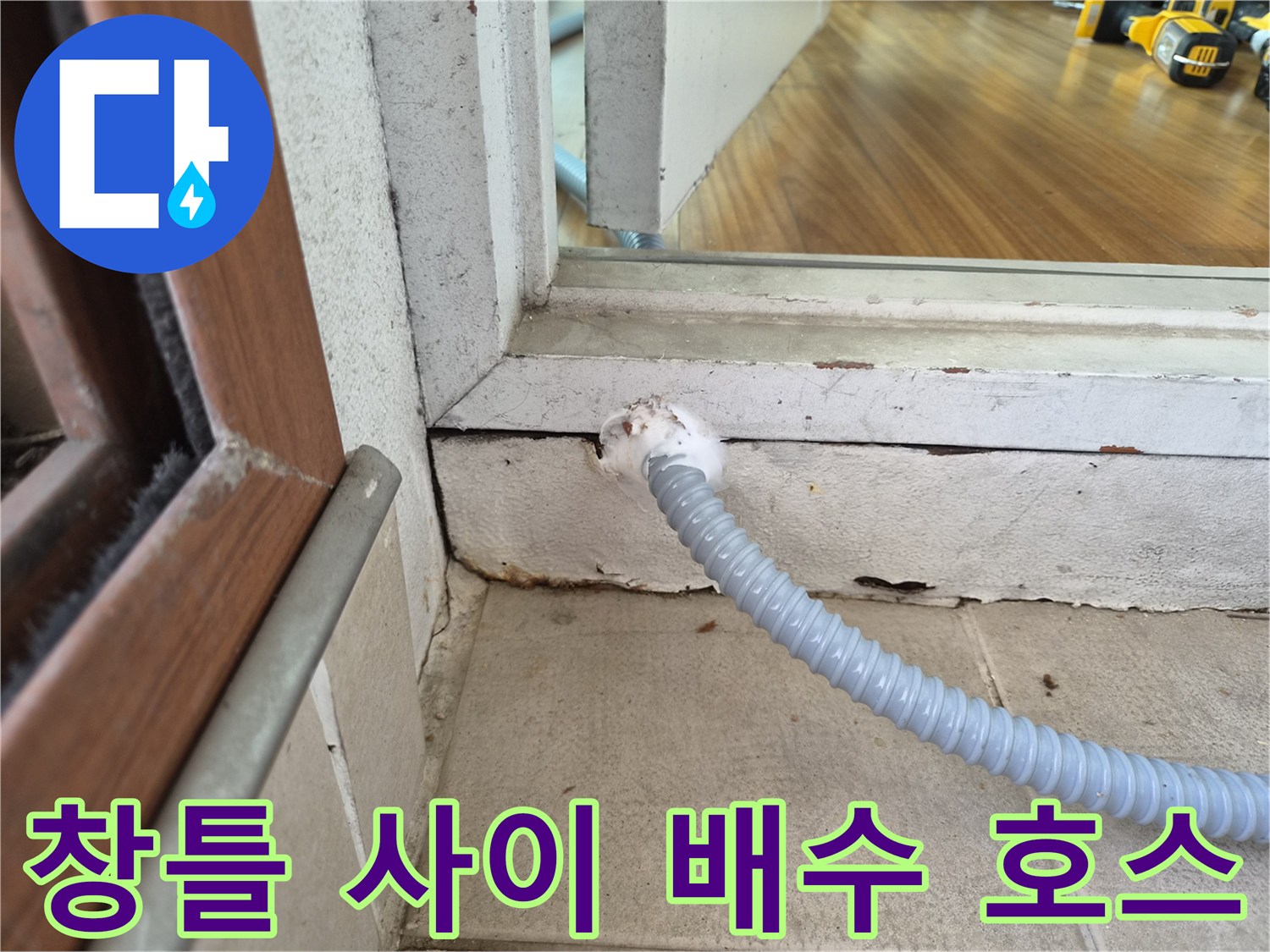 벽면 틈새로 연결된 회색 주름관과 창틀 하단부 모습