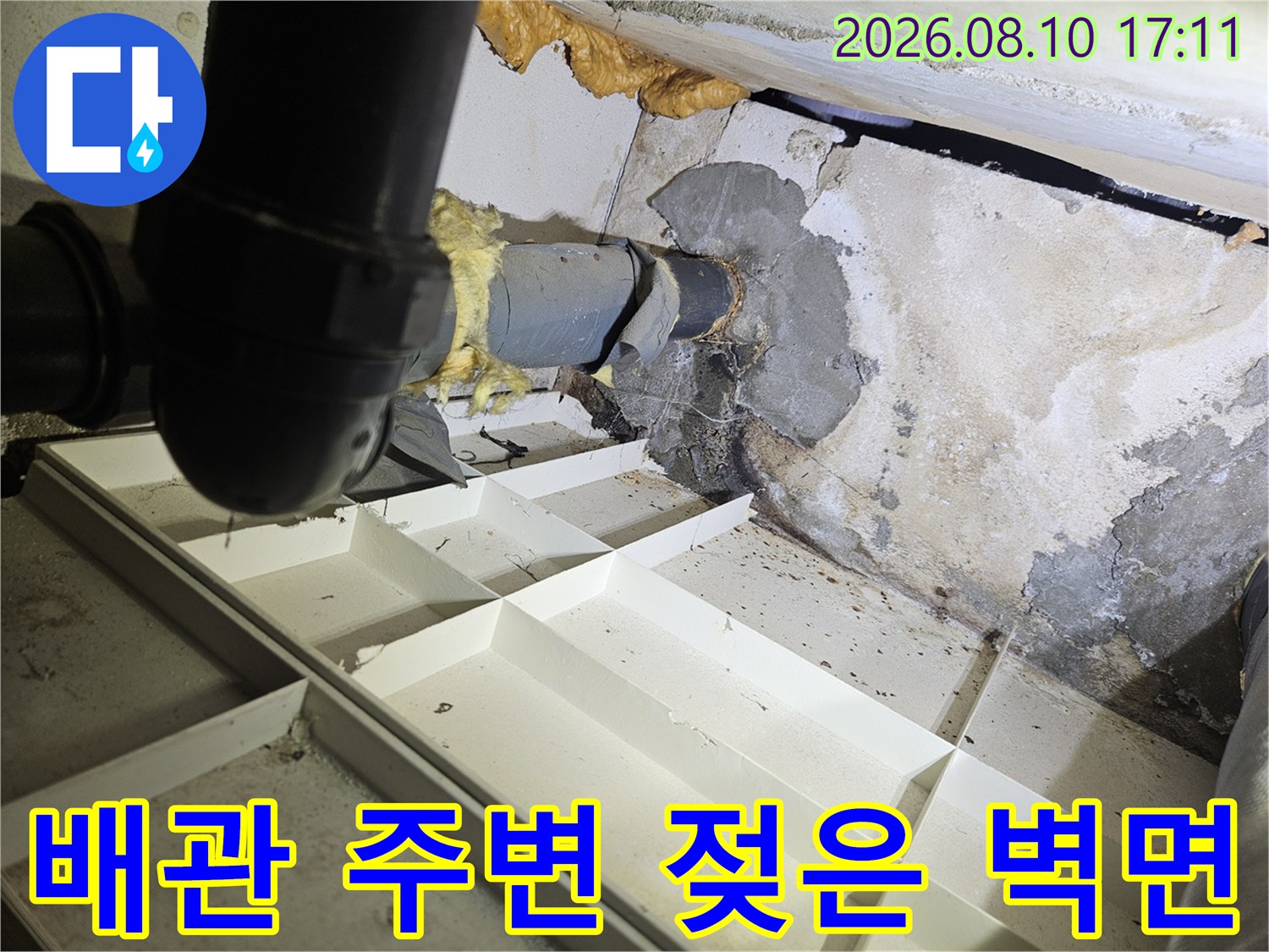 화장층 천장 내부 배관 주위의 습기 찬 콘크리트 모습입니다.