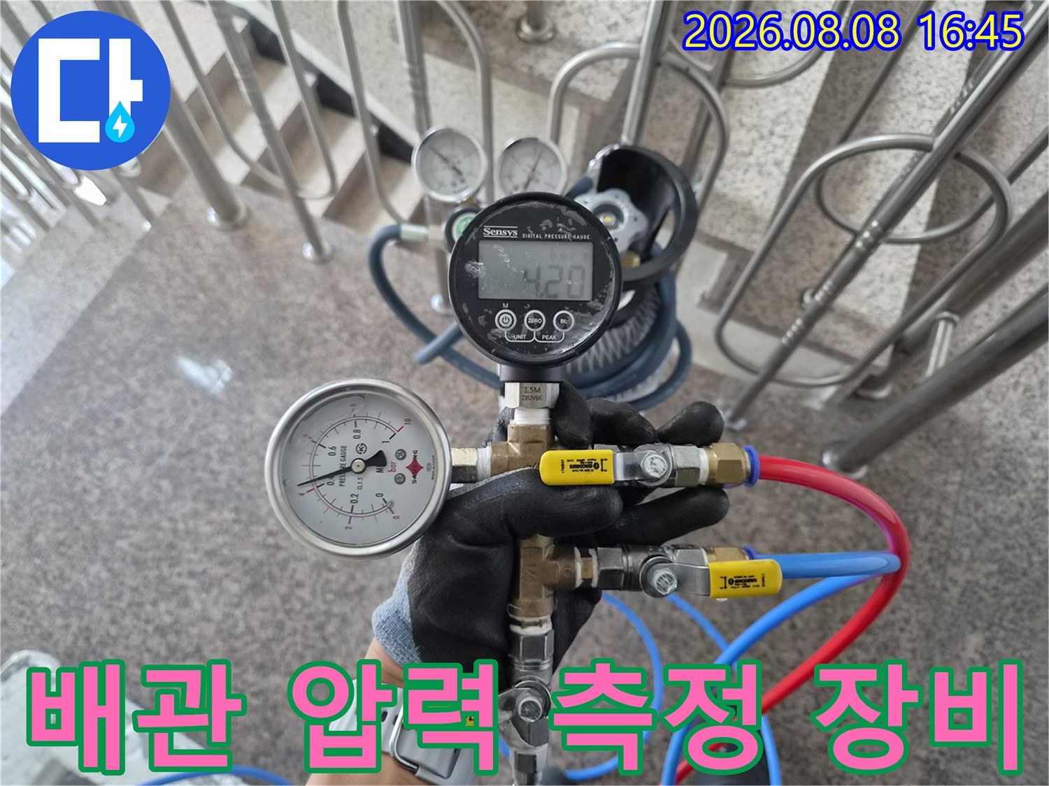 파란색과 빨간색 호스가 연결된 배관 압력 측정용 게이지 장치
