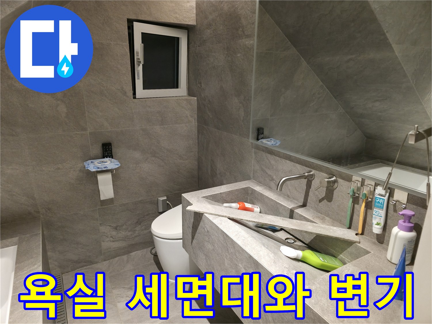 세면대 아래쪽 수전과 변기가 설치된 화장실 내부 전경