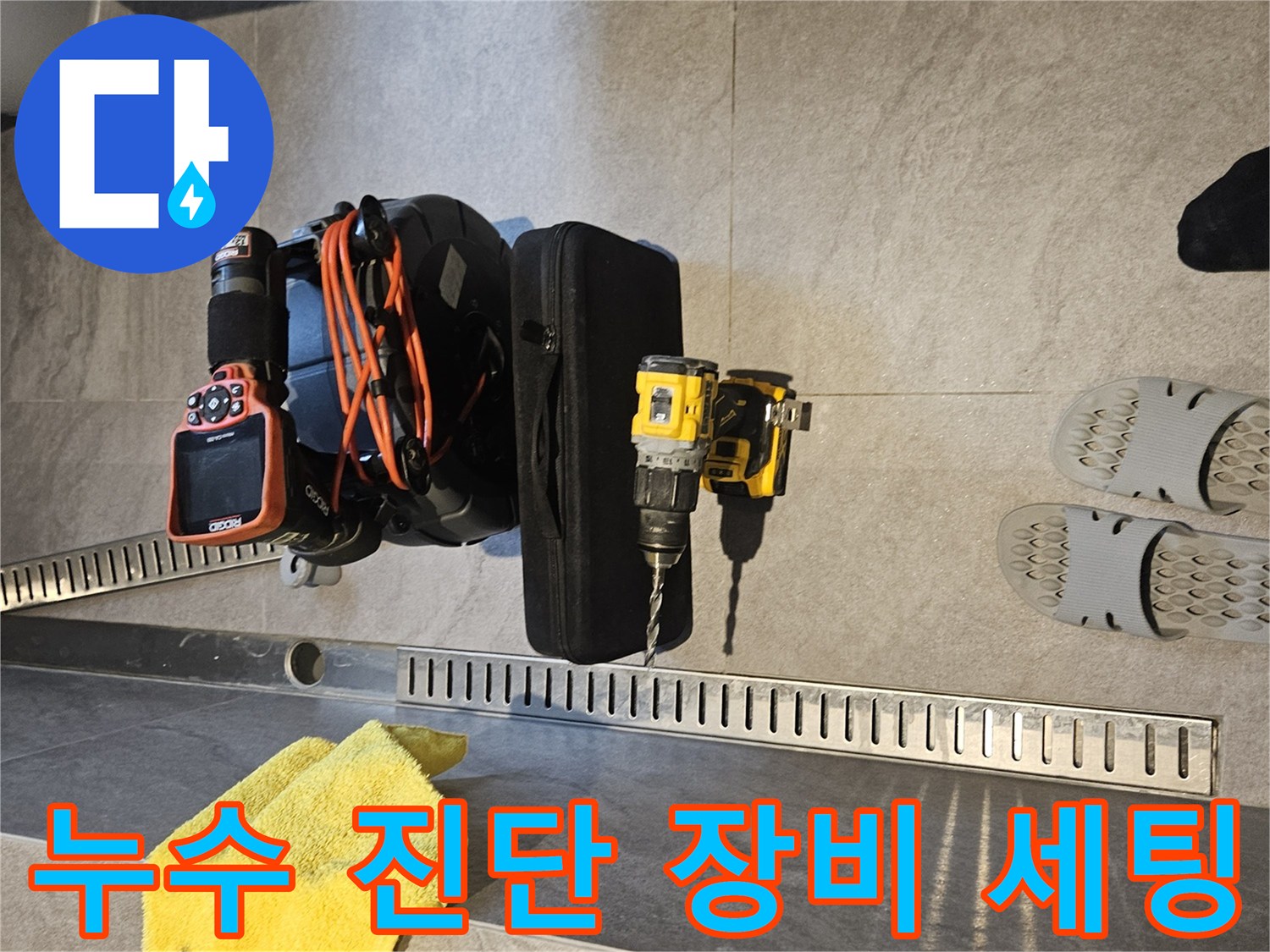화장실 바닥에 놓인 내시경 카메라와 전동 드릴 장비