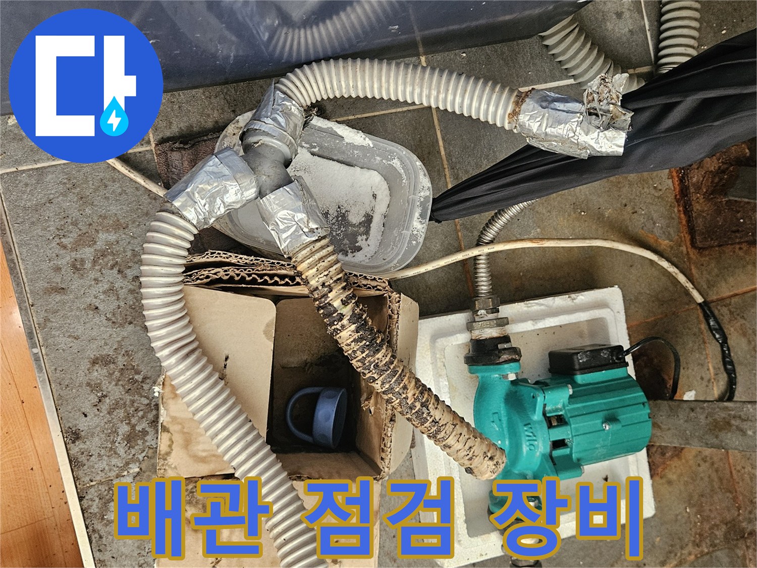 하수 배관 연결 부위와 펌프를 이용한-배수 점검 작업 중인 모습