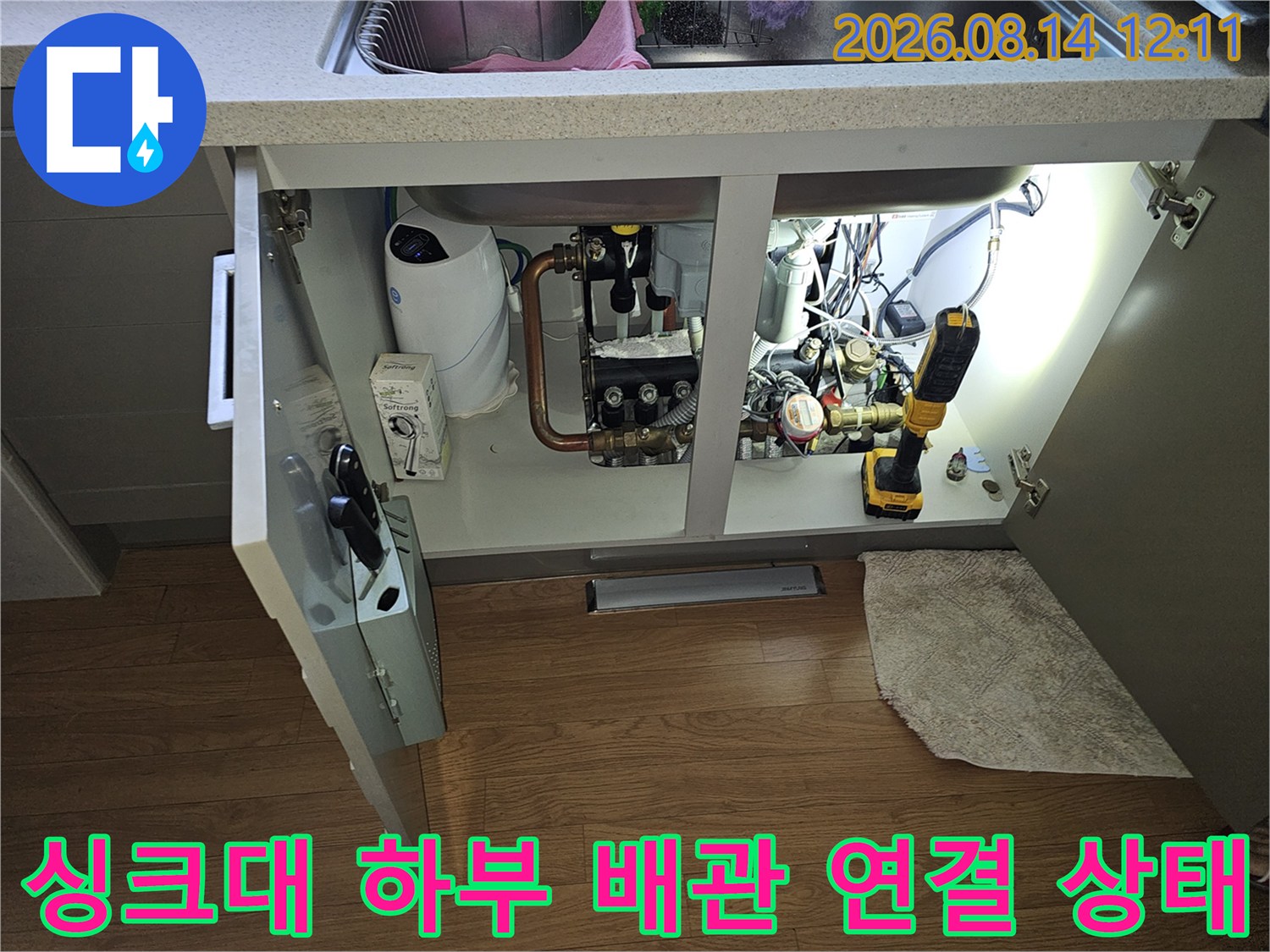 싱크대 아래쪽 수도 계량기와 배관 부속들의 점검 모습