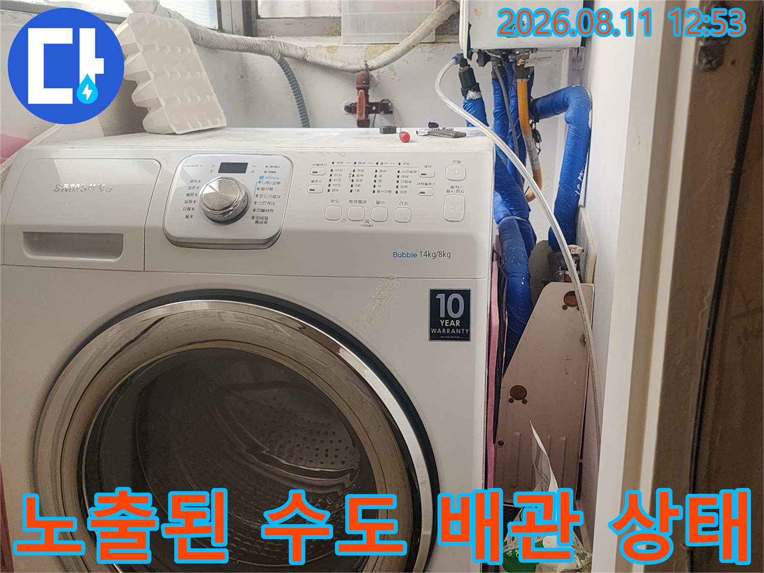 세탁기 뒤편에 위치한 파란색 배관과 보일러 부속품들의 상세 모습입니다.