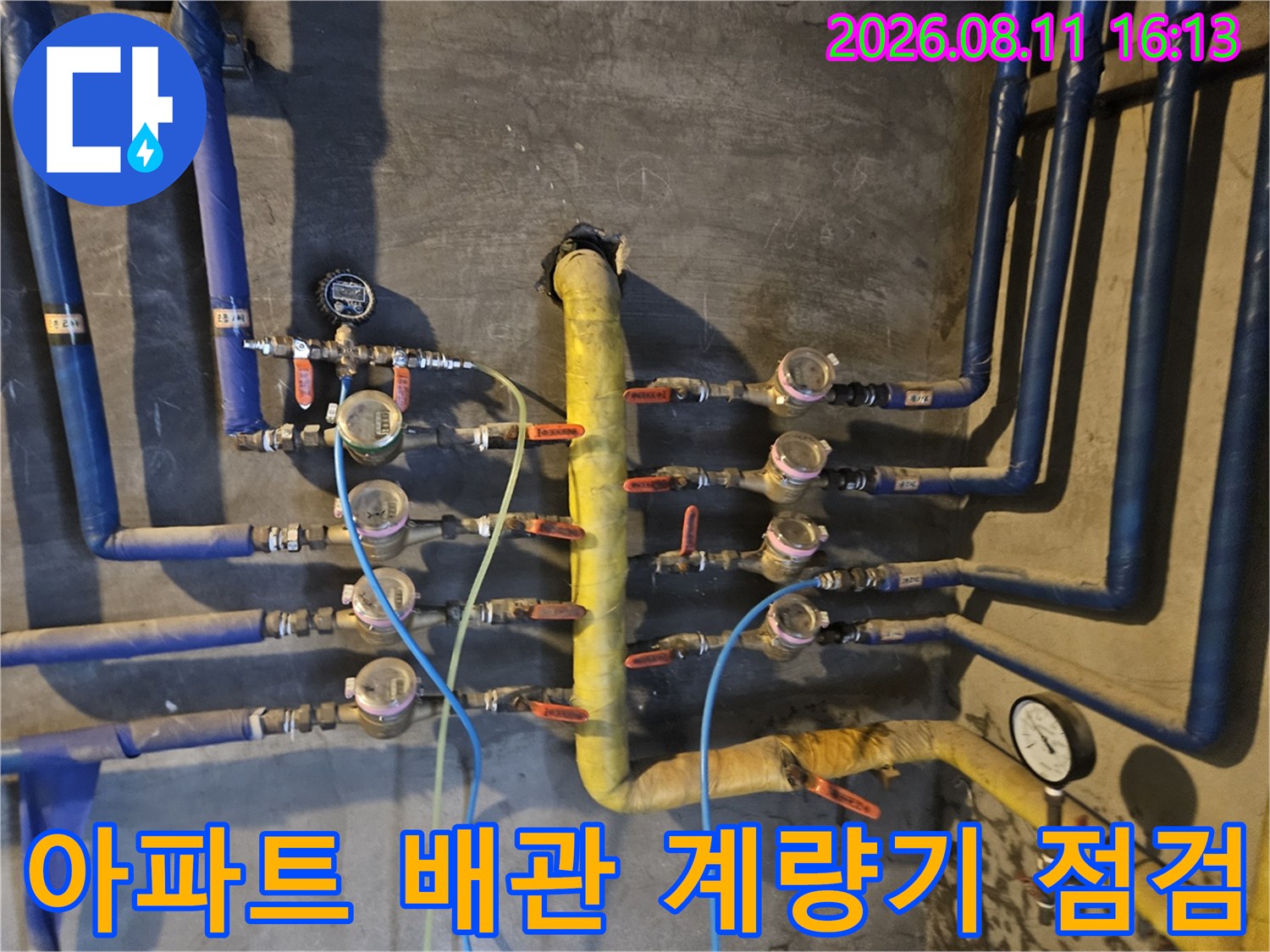 삼성동 아파트 내부의 파란색과 노란색 배관 및 수도 계량기 모습