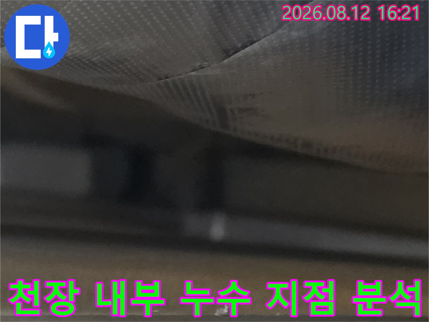 회색 단열재-흰색 천장 구조물 사이의 습기 맺힘 현상을 보여주는 사진