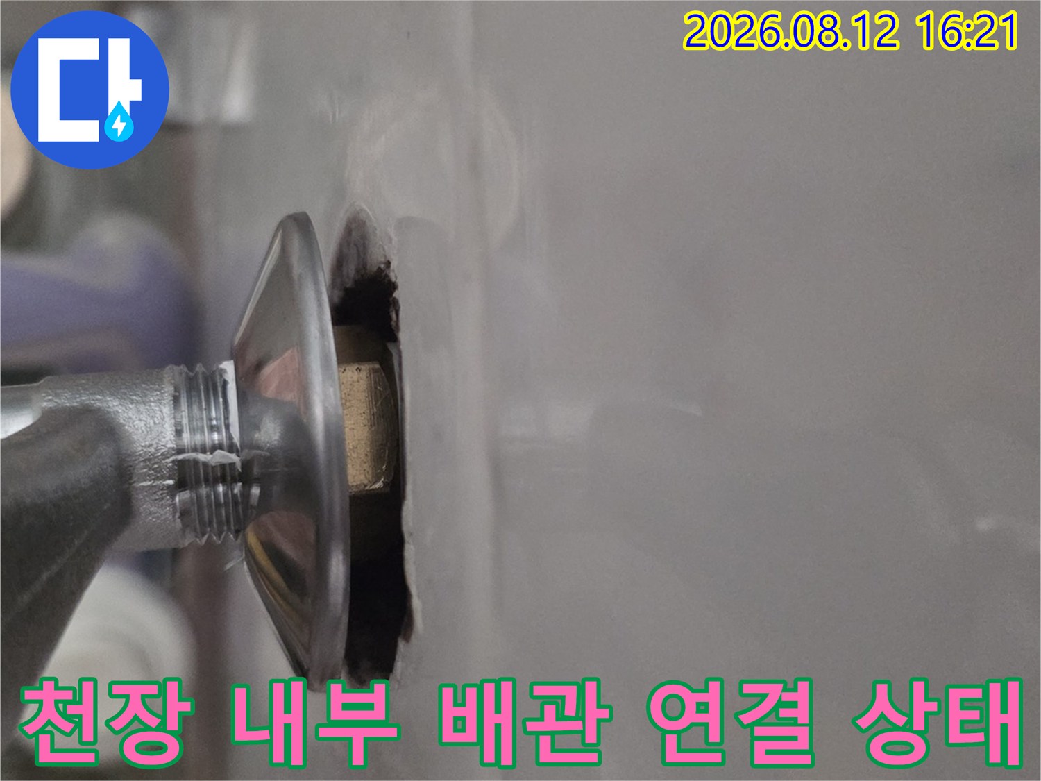 흰색 천장재 하단에 설치된 원형 금속 배관 연결부-클로즈업 사진