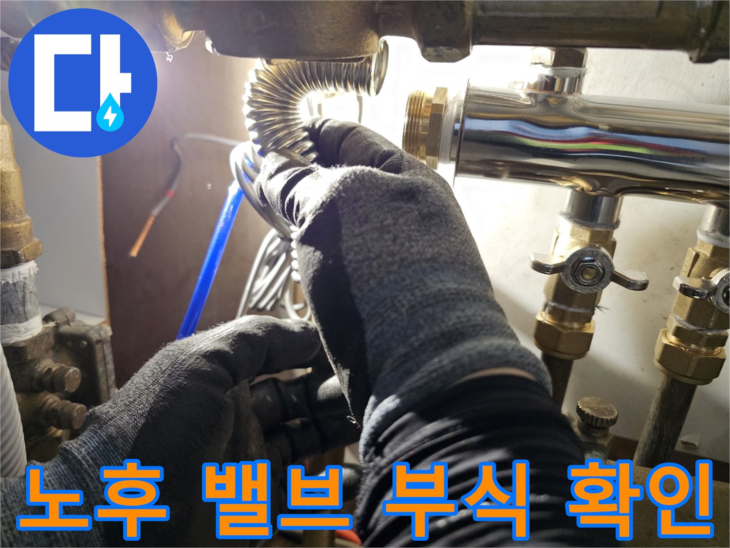 금속 배관의-연결 부위와 밸브 상태를 자세히 관찰하는 작업자