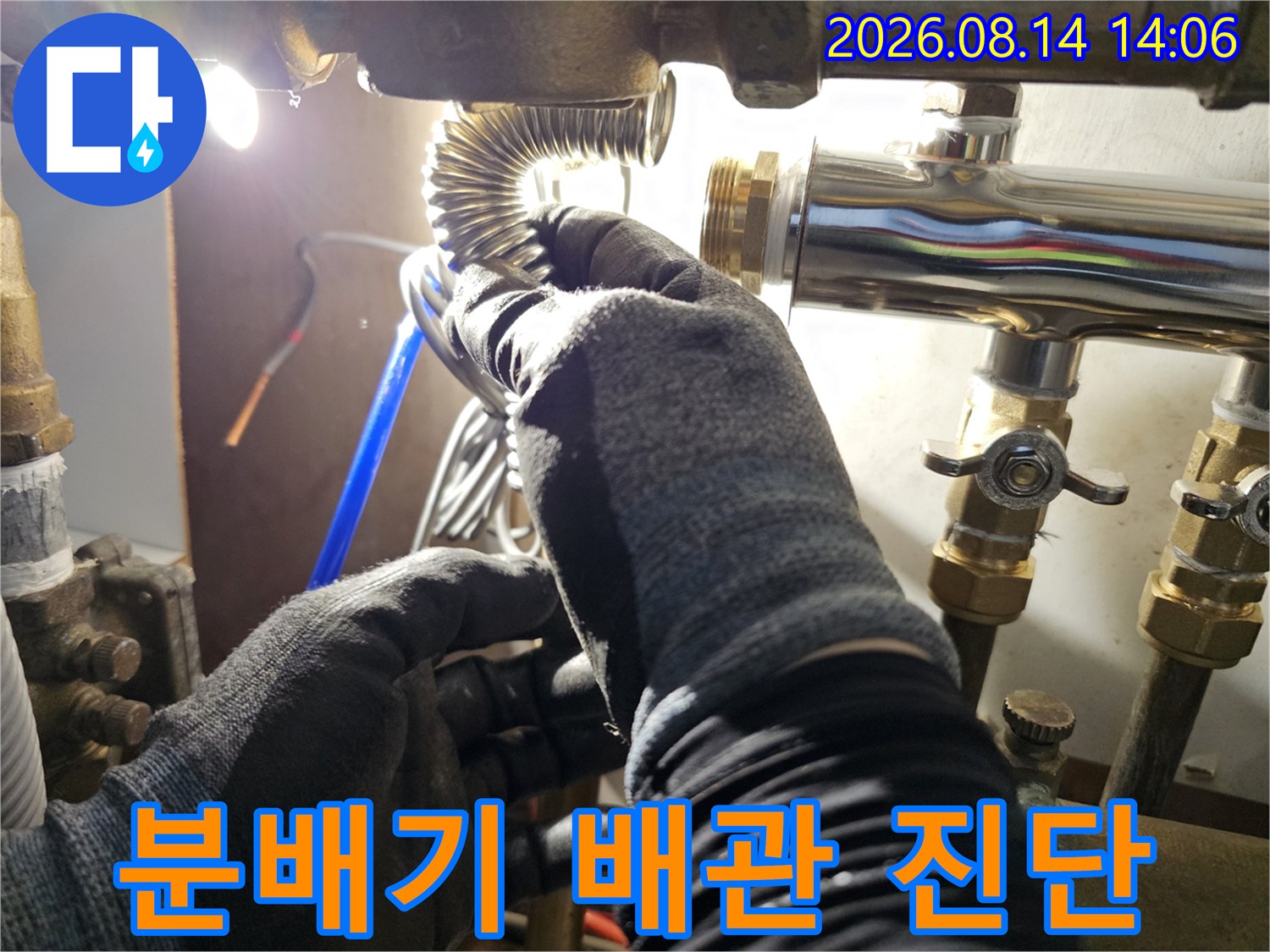 작업자가 분배기의 밸브와 연결 배관을 면밀히 관찰하는 모습입니다.