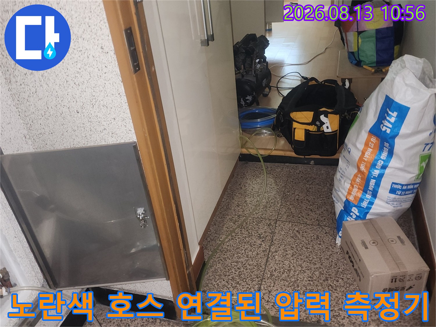 금속제 점검구 덮개 옆으로 노란색 공압 호스가 복잡하게 연결되어 있는 현장 사진