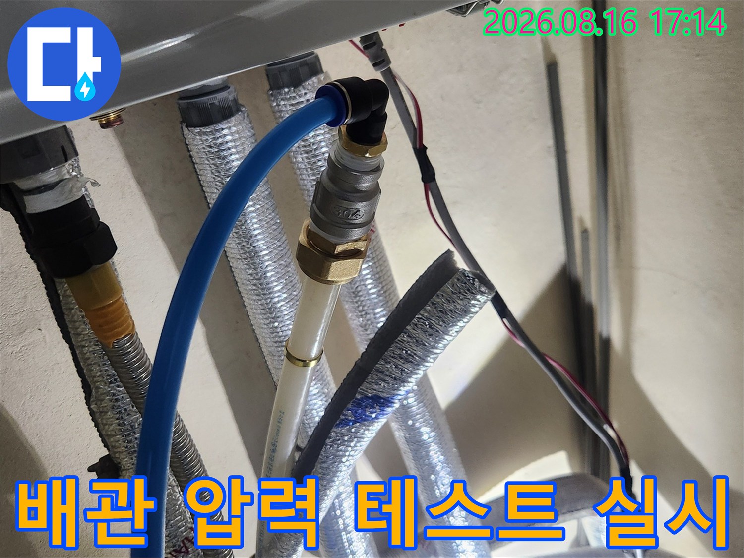보온재로 감싸진 다수의 배관에 공압 장비를 연결하여 검사 중입니다.
