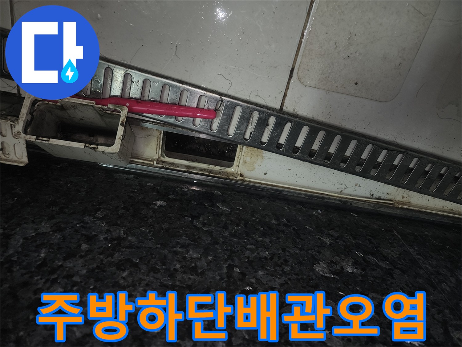 싱크대 하부 배수구 주변의 젖은 흔적과 오염된 마감재