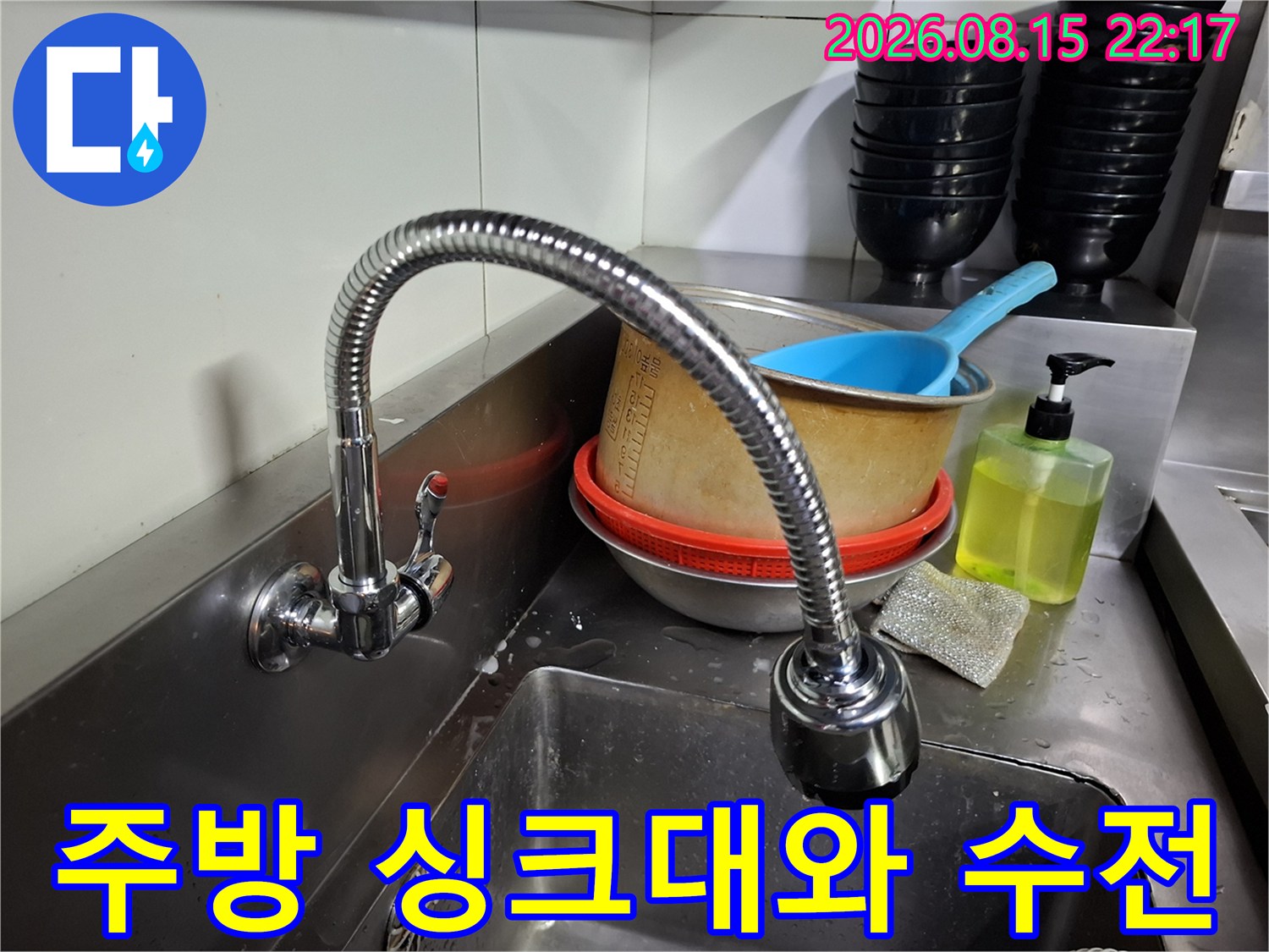 식당 주방 스테인리스 싱크대 상단에 설치된 유연한 형태의 수전 모습