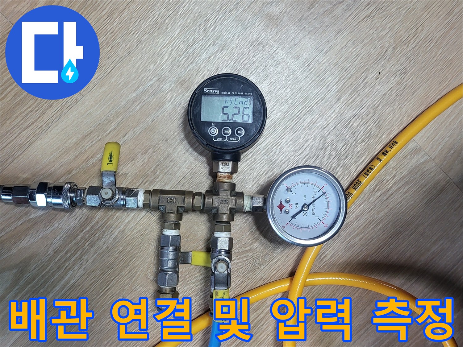 노란색 호스와 파란색 호스가 연결된 배관 압력 테스트 장비