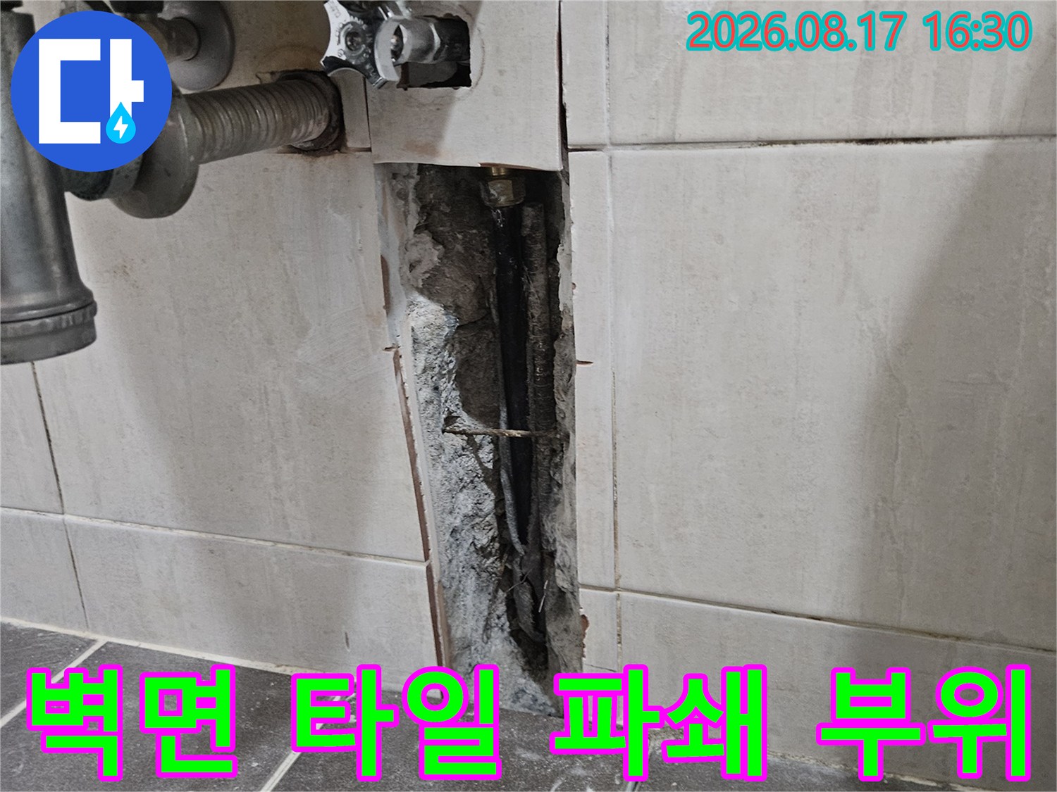 세면대 배관 확인을 위해 벽면 타일을 파쇄하여 내부를 드러낸 모습입니다.