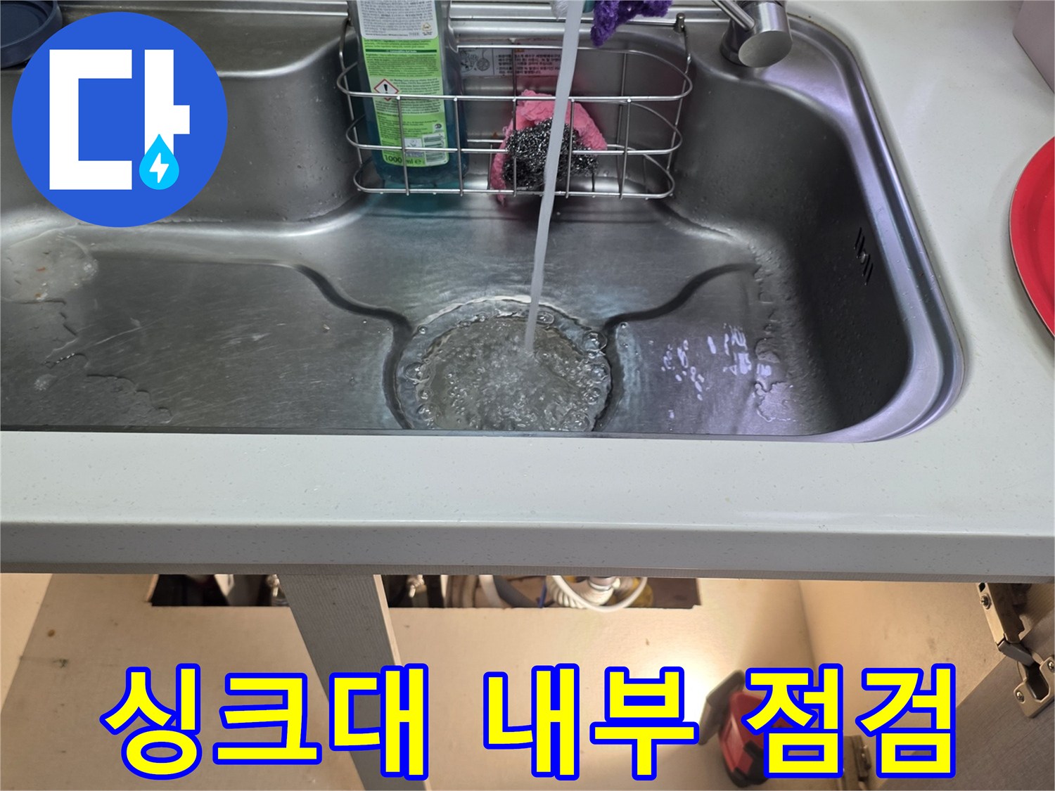 스테인리스 싱크대 볼과 주변에 배치된 세제 및 호스들의 근접 촬영-누수 진단 중