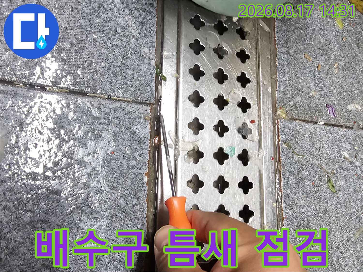 송파구 가락동 현장의 배수구 틈새를 도구를 사용하여 세밀하게 확인하는 모습입니다.