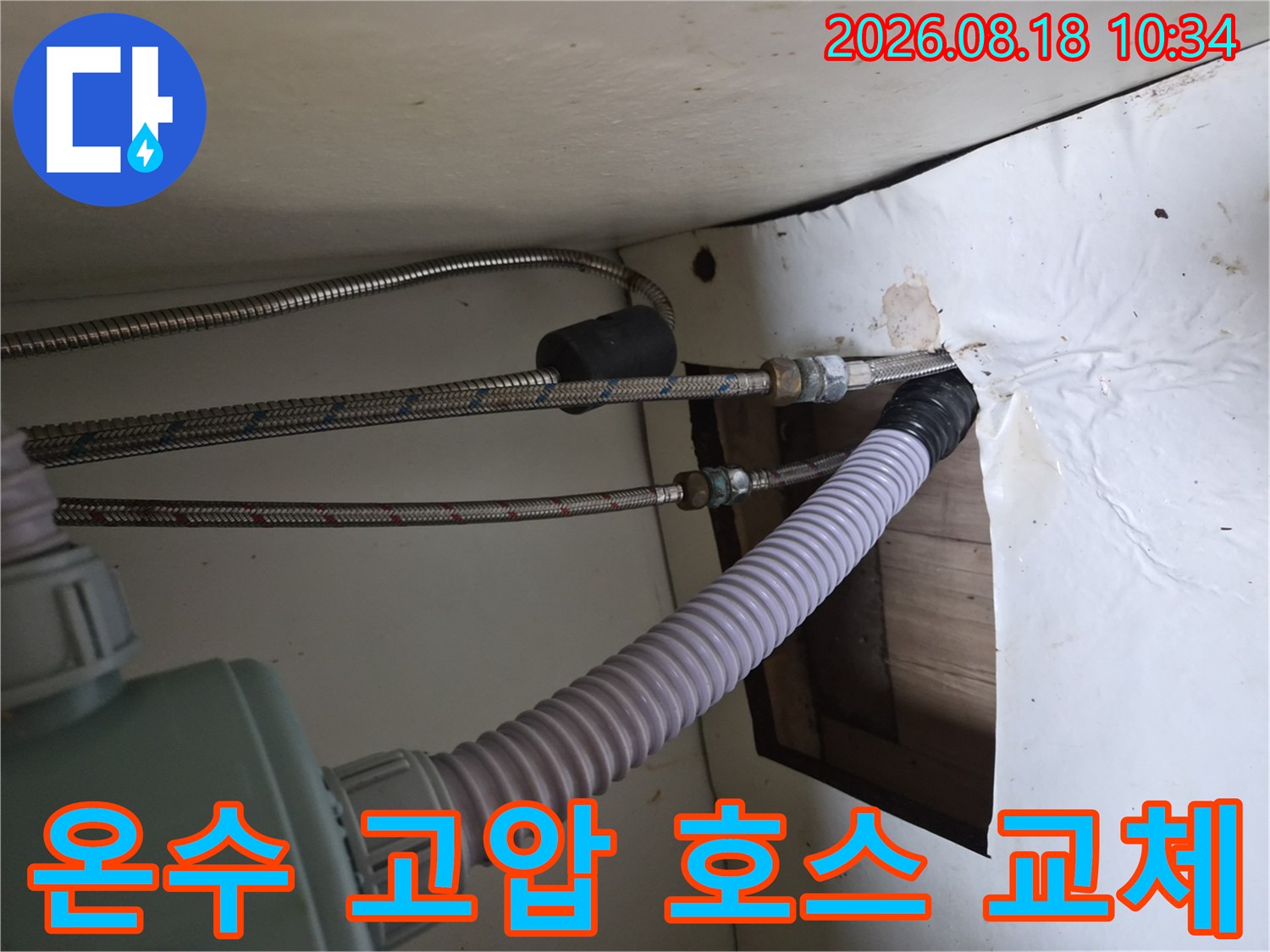 싱크대 하부장 내부-파손된 온수 배관과 새롭게 설치된 호스의 연결 상태입니다.