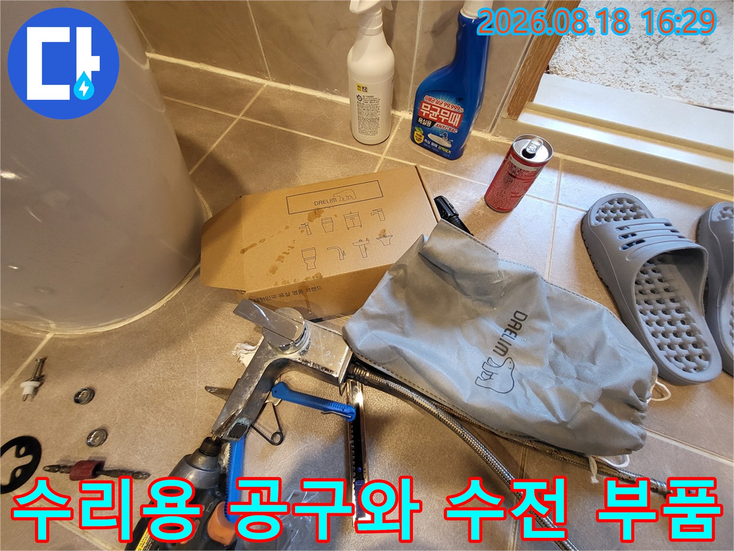 욕실 세면대 누수 보수를 위해 바닥에 나열된 작업 도구와 새 자재들