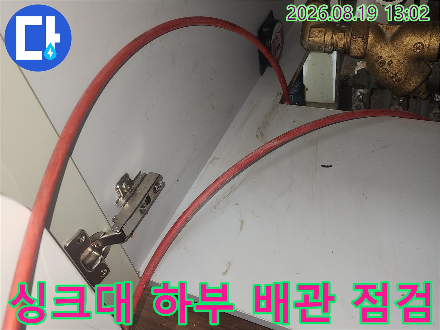 싱크대 밑 수도 밸브와 붉은색 호스 연결 부위 근접 촬영