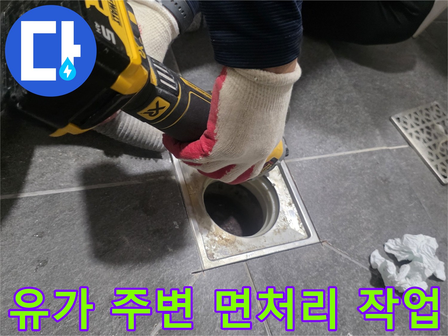 전동 드릴을 사용하여 배수구 주변 타일 단면을 정리하고 있습니다.