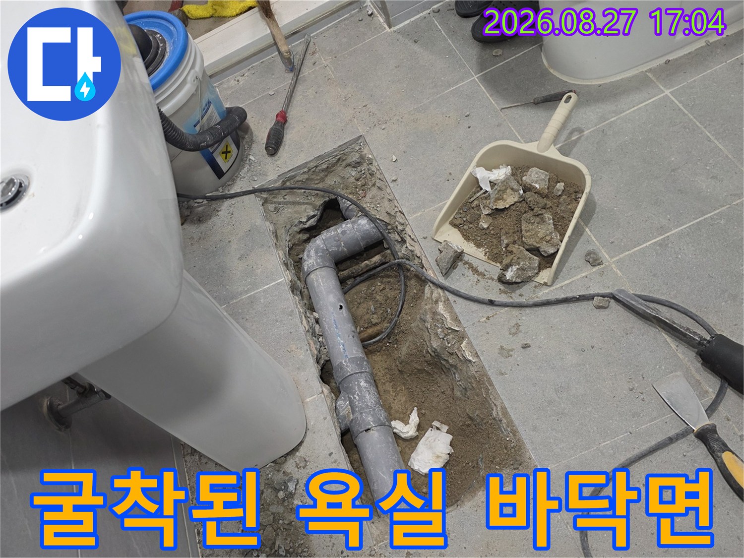세면대 아래쪽 타일을 걷어내고 노출시킨 배관과 공사 장비들