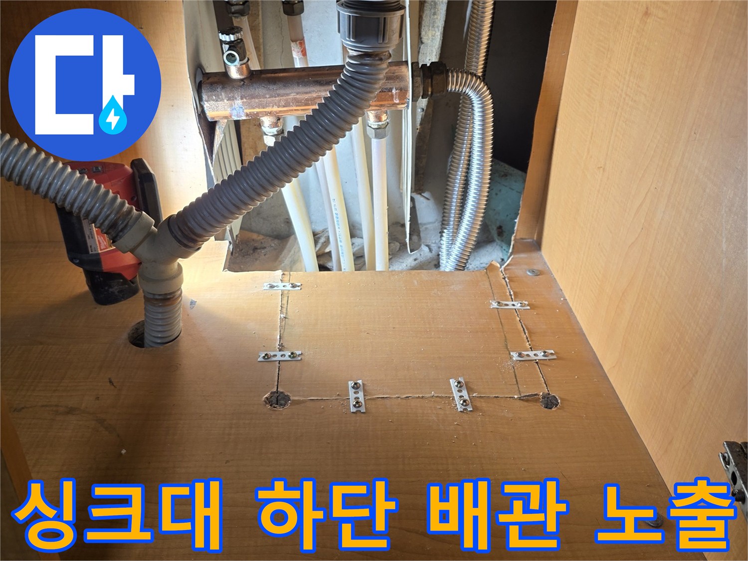 싱크대-내부-노출된-구리-배관과-회색-주름관-연결-상태