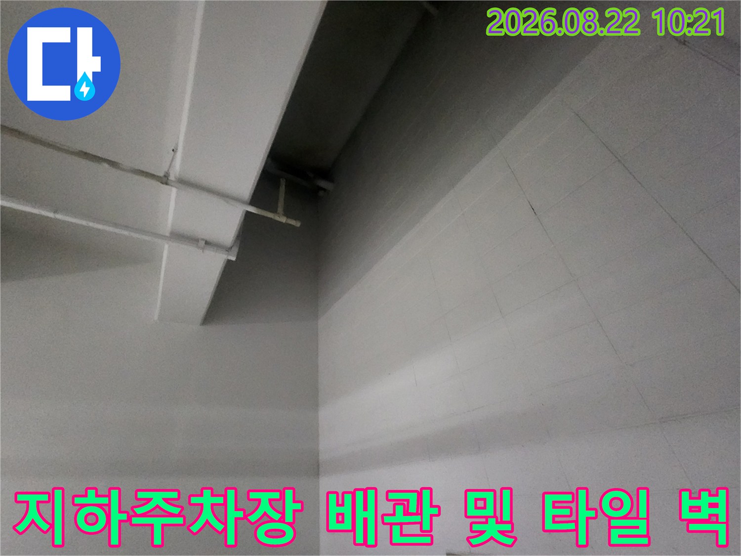흰색 배관과 타일로 마감된 지하주차장 천장 내부 모습