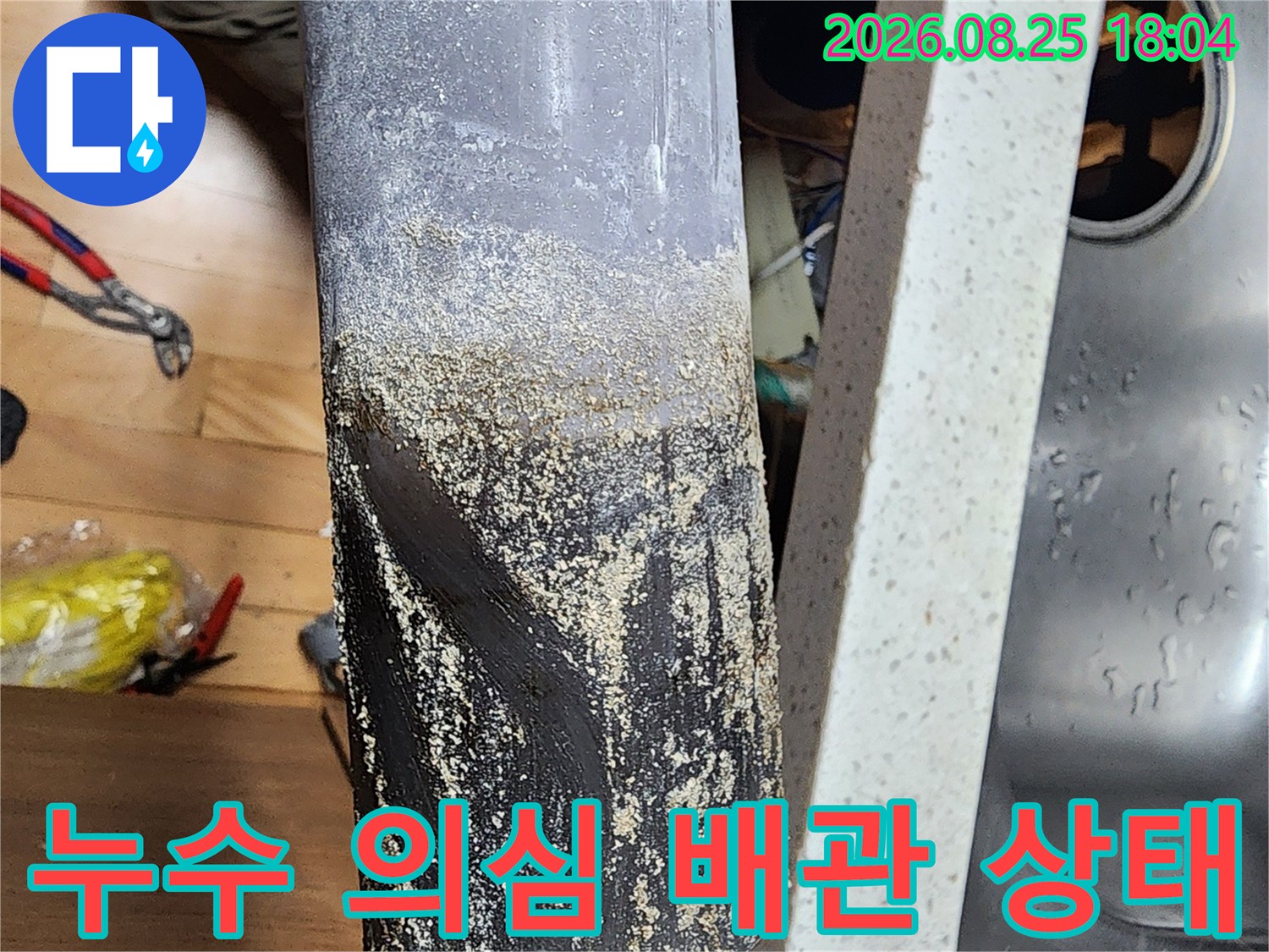 습기와 이물질로 오염된 싱크대 하단 배수관 근접 촬영