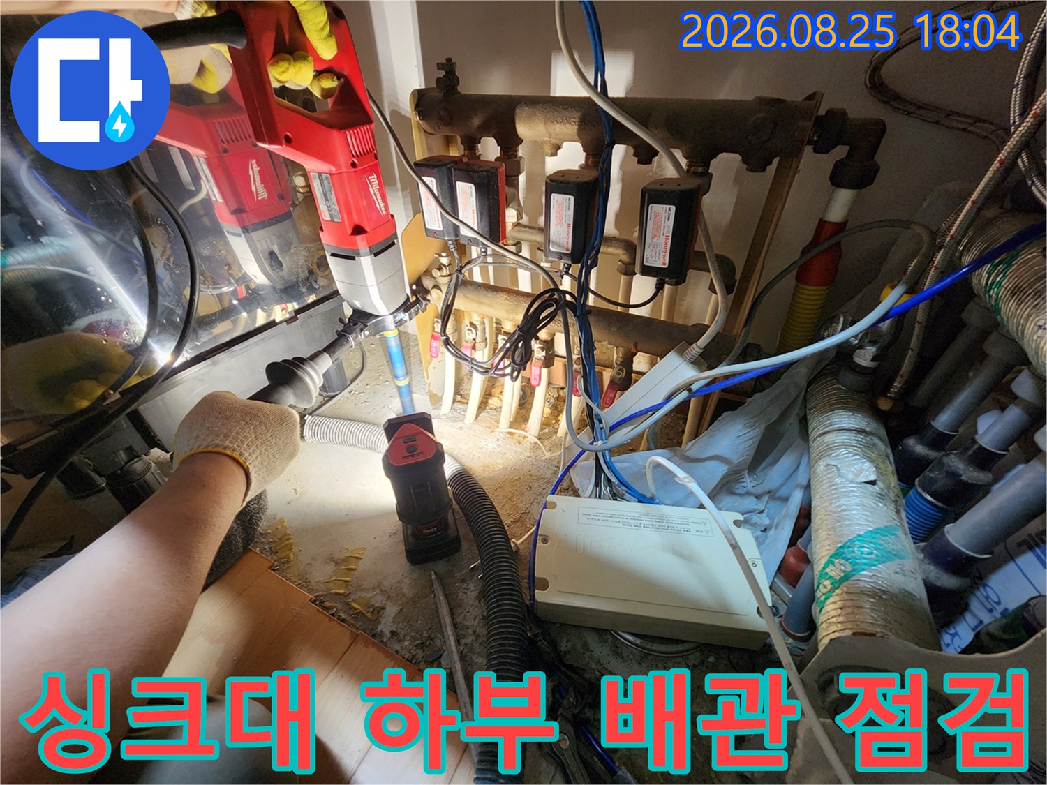 인천 남동구 구월동 싱크대 하부장 내부의 복잡한 배관과 누수 확인을 위한 전동 드릴 작업 현장