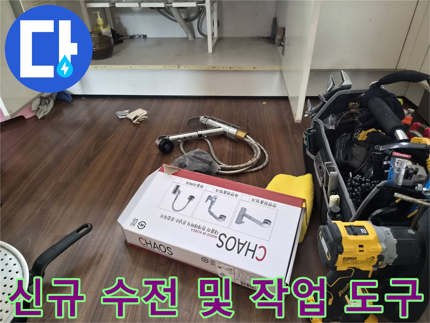 싱크대 밑 작업 구역에 놓인 새 수전 박스와 전동 드릴 장비