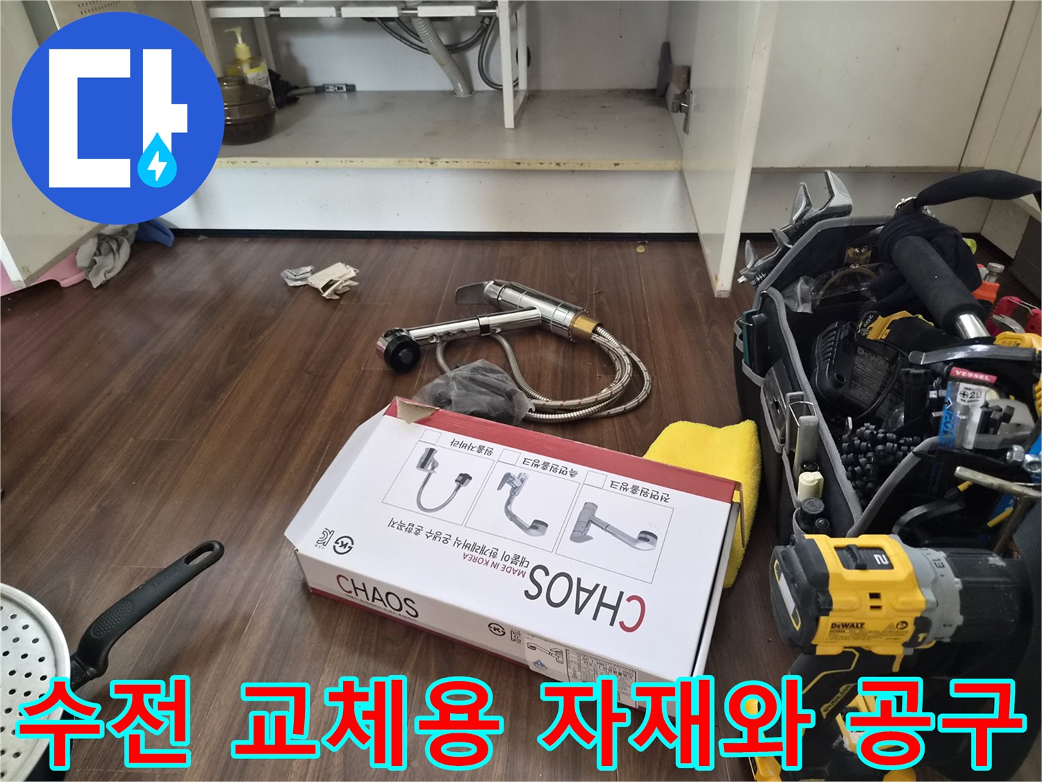싱크대 하단 작업 공간의 새 수전 상자와 전동 드릴 도구들