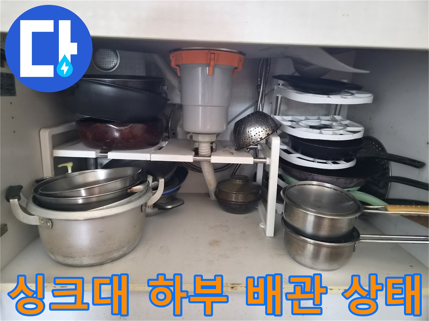 싱크대-하부장-내부의-복잡한-배관과-수납물-모습