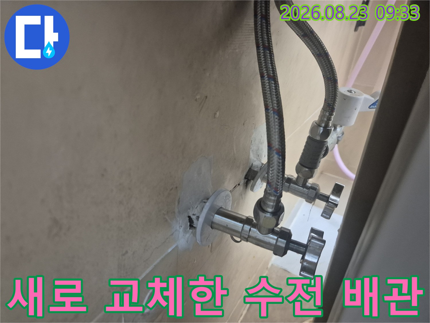 금속 소재의 튼튼한 수전 호스가 벽면 밸브에 연결된 상태입니다.
