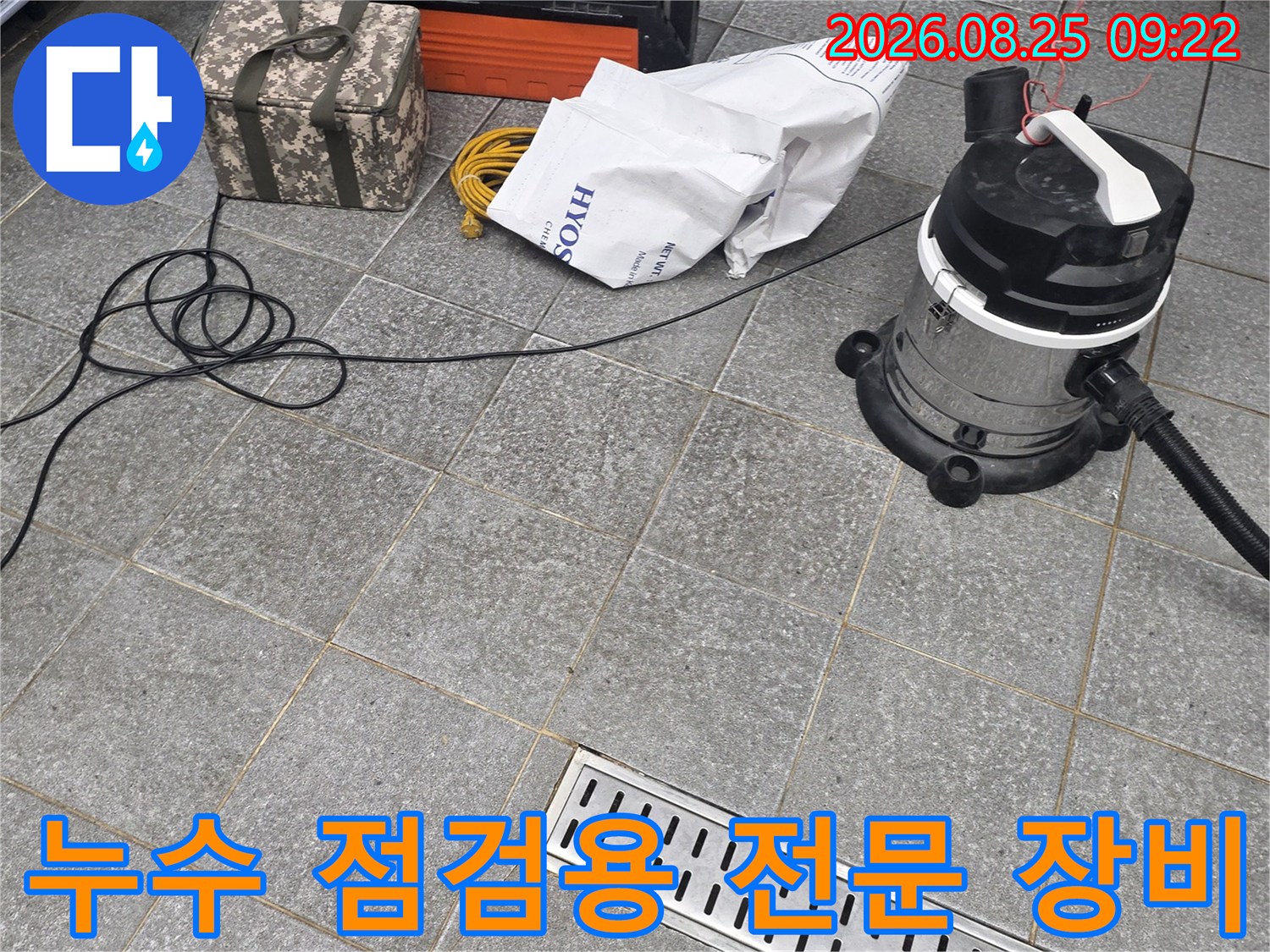 트렌치 배수구 옆에 준비된 산업용 청소기와 공구 상자