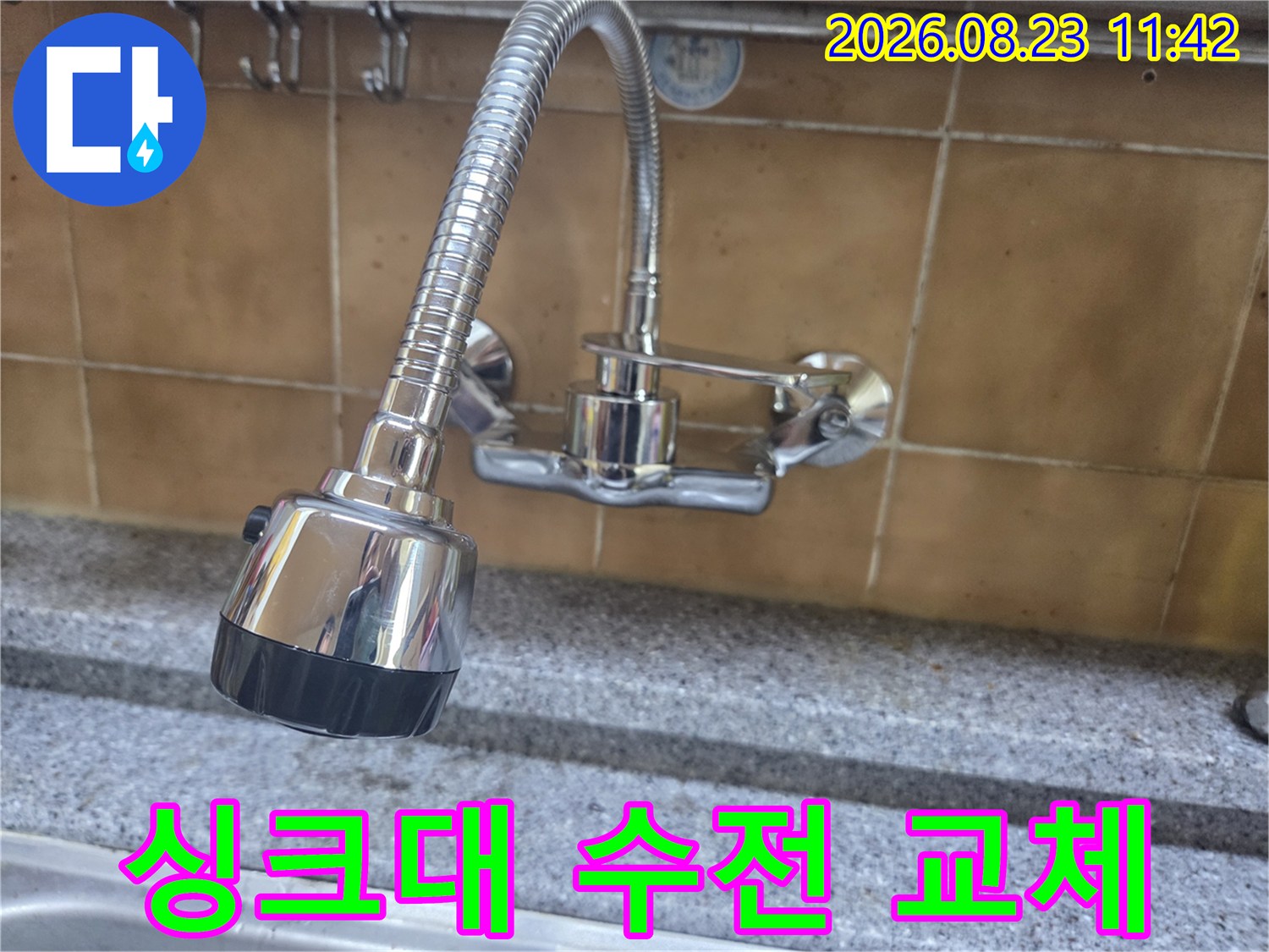 벽면 타일 부근에 설치된-금속제 싱크대 수전의 근접 사진입니다.