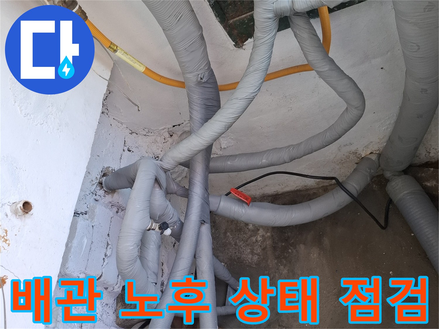 보온재로 감싸진 배관들과 벽면 균열 사이의 배관 연결 부위 촬영