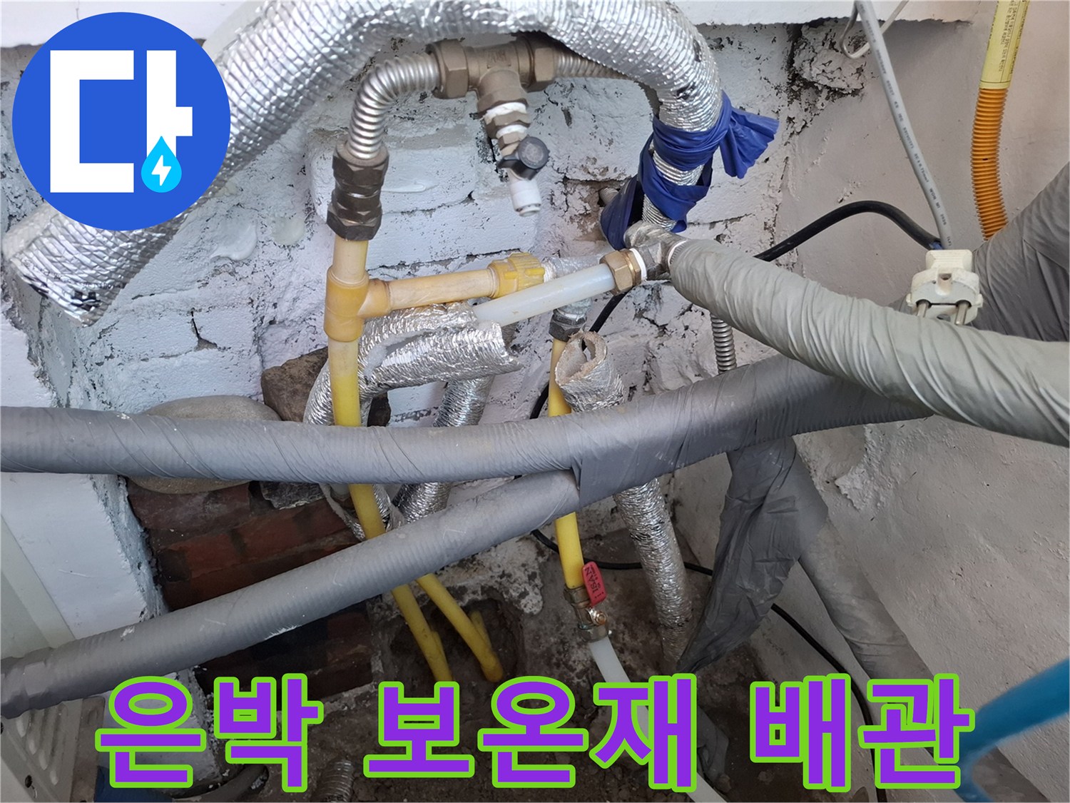 보일러실 내부에 설치된 은박 보온재와 노란색 직수 배관의 모습