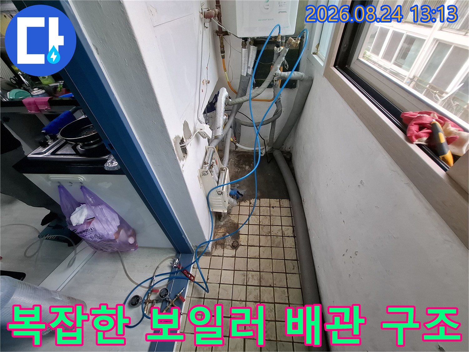 보일러실 바닥 타일 부근에 위치한 다양한 수도 배관과 연결 자재들입니다.