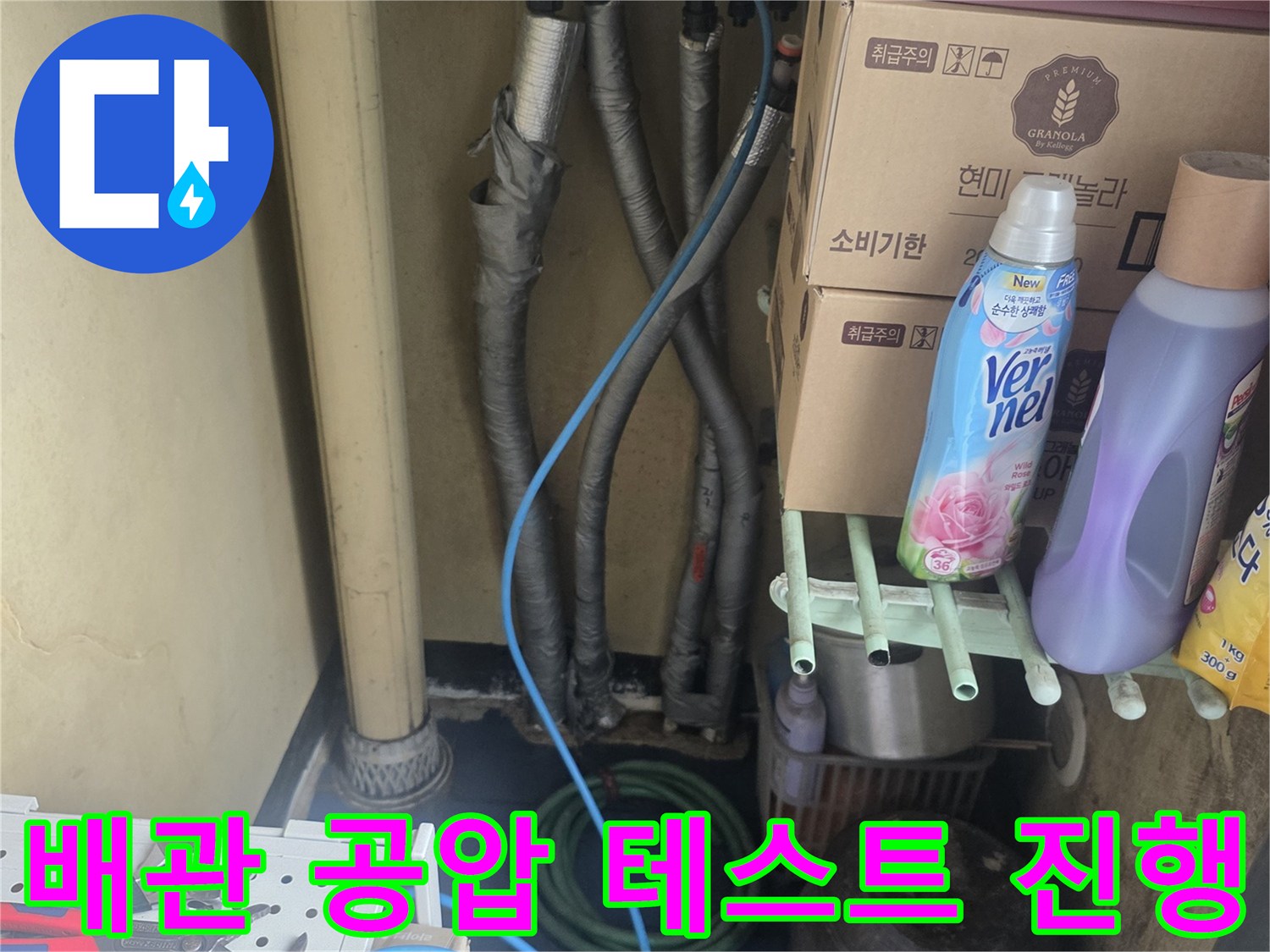 보일러실 배관에 연결된 파란색 호스와 주변 작업 환경을 보여줍니다.