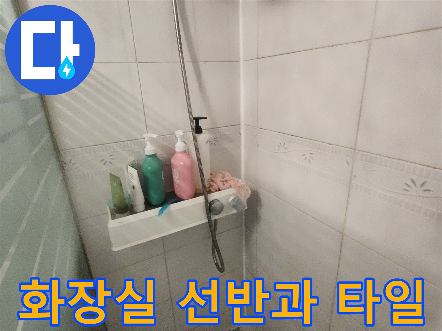 욕실 선반 위에 놓인 용품들과 하얀 타일 벽면