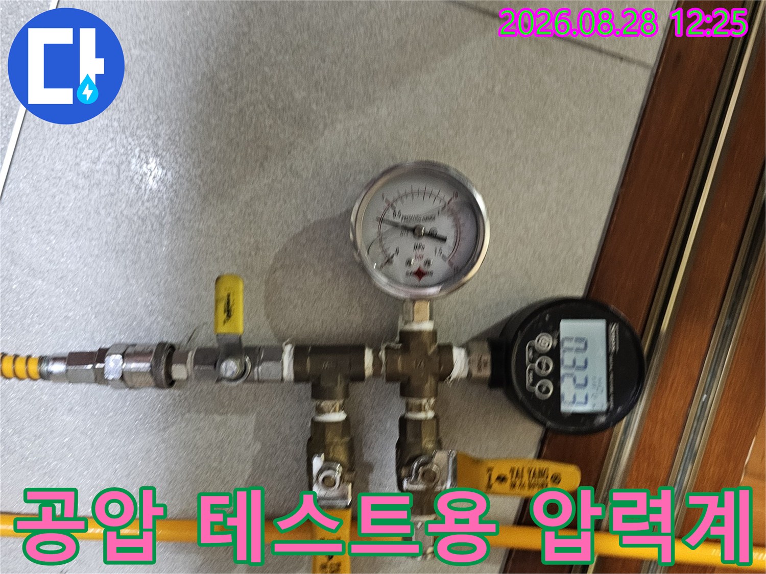 배관 연결부에 노란색 호스와 압력계를 설치하여 수치를 측정하고 있습니다.