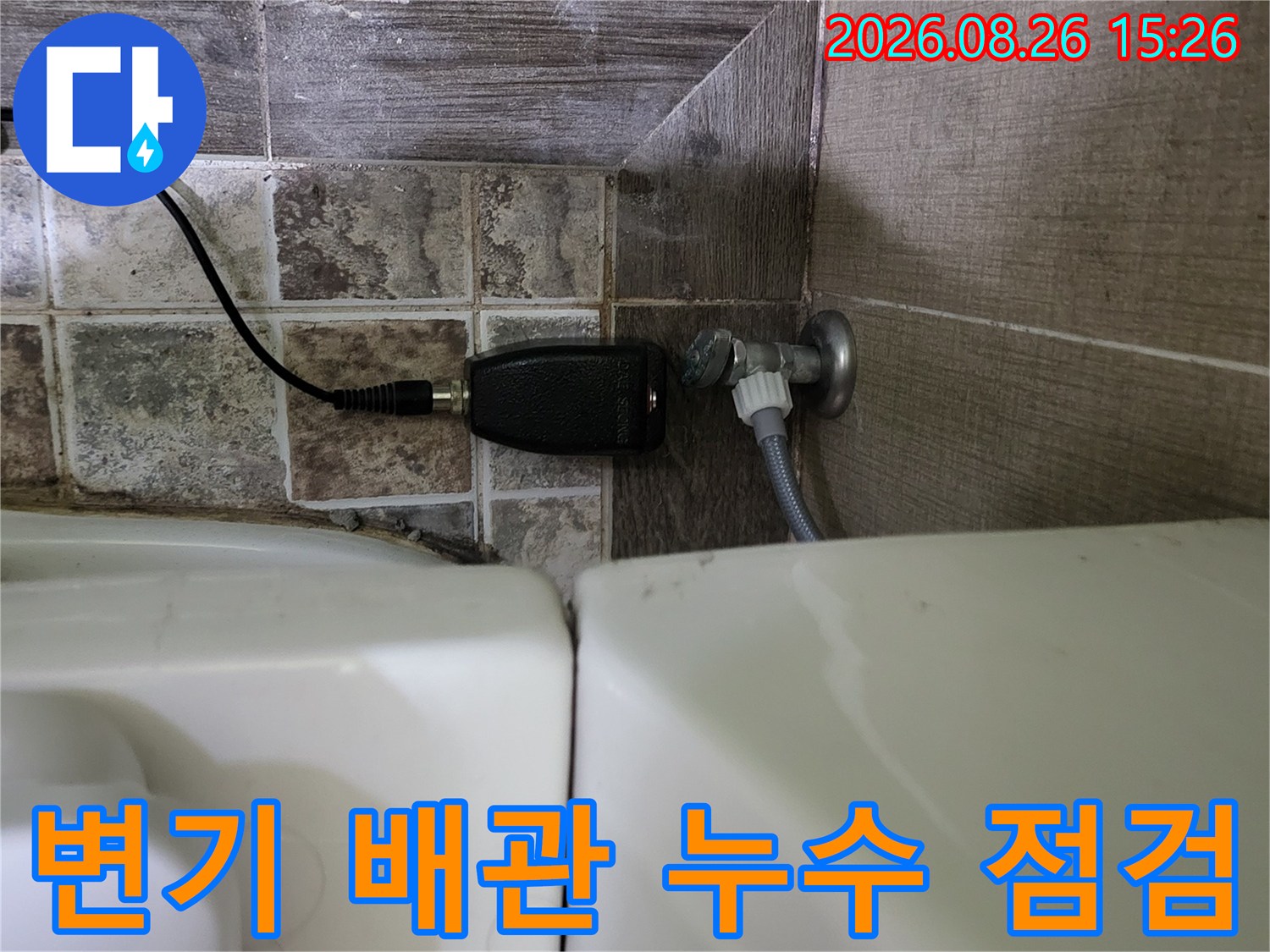변기 옆쪽 배관 연결 부위에 탐지기를 설치하여 누수를 확인하고 있습니다.