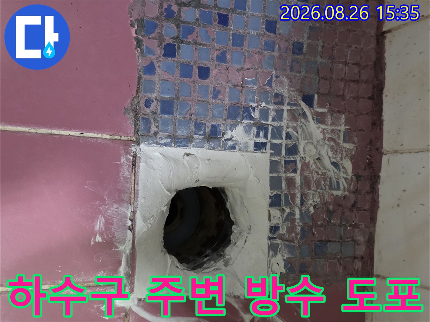 분홍색 타일과 배수구 주변의 하얀색 방수재 시공
