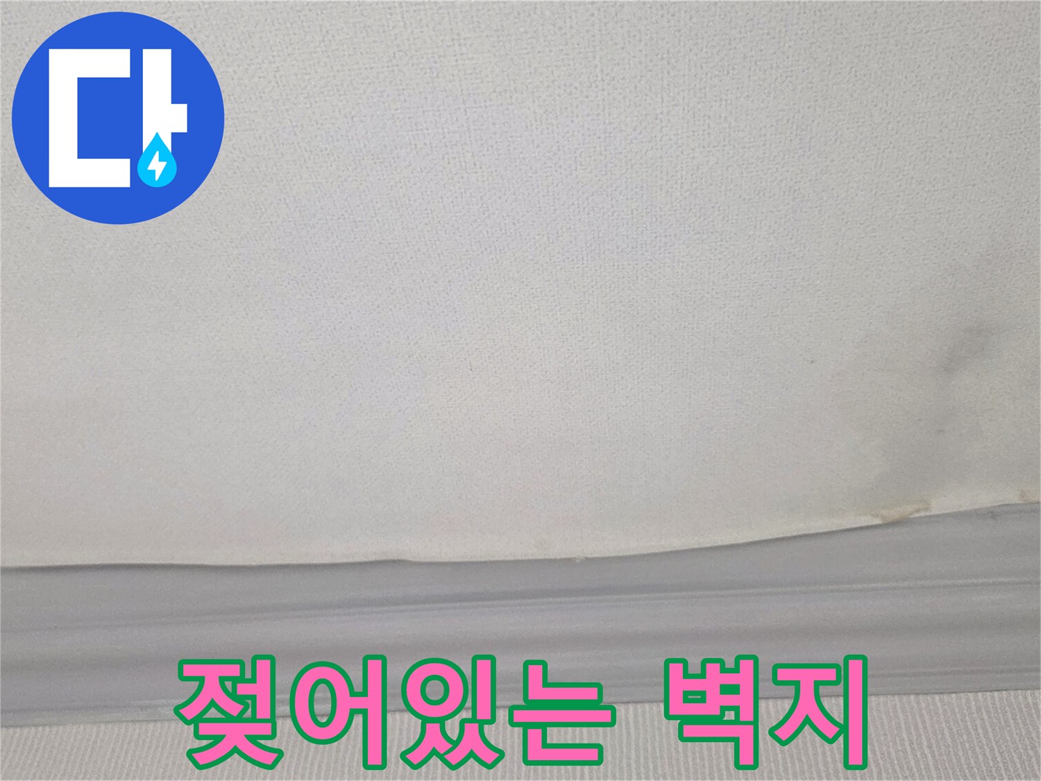 천장 벽지가 물에 젖어 어둡게 변색된 누수 피해 부위