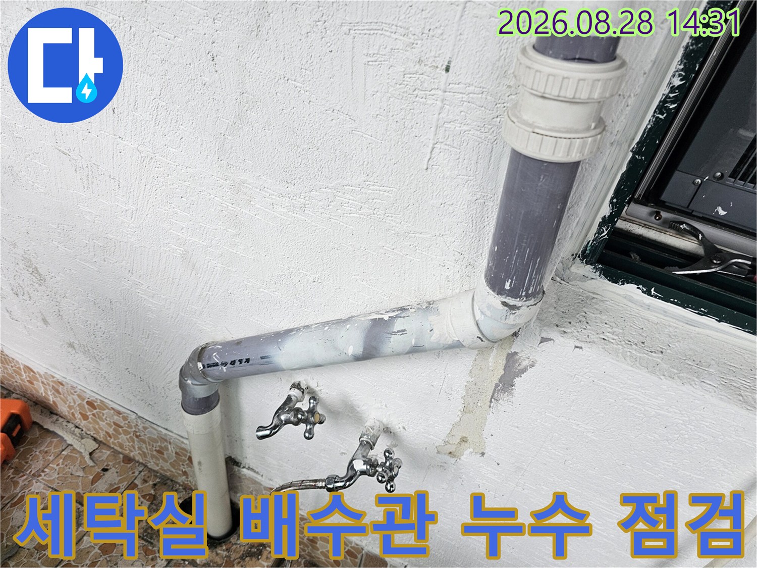 베란다 벽면에 설치된 수도꼭지와 수평으로 연결된 배수관 모습입니다.