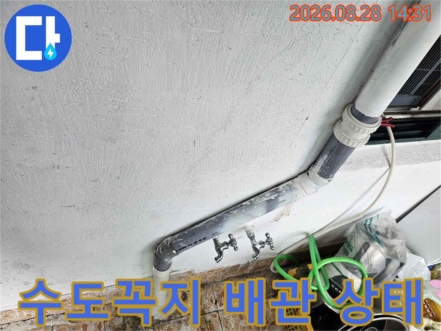 벽면에 설치된 수도꼭지와 꺾여 있는 배수관 연결 부위 상세