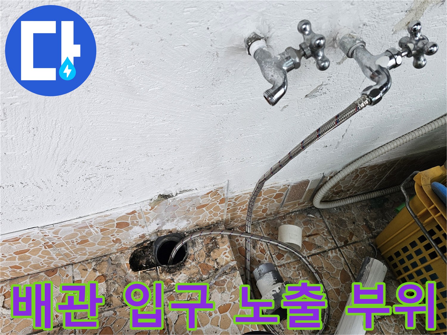 수도꼭지 아래 벽면과 바닥 배관이 보이는 현장 사진