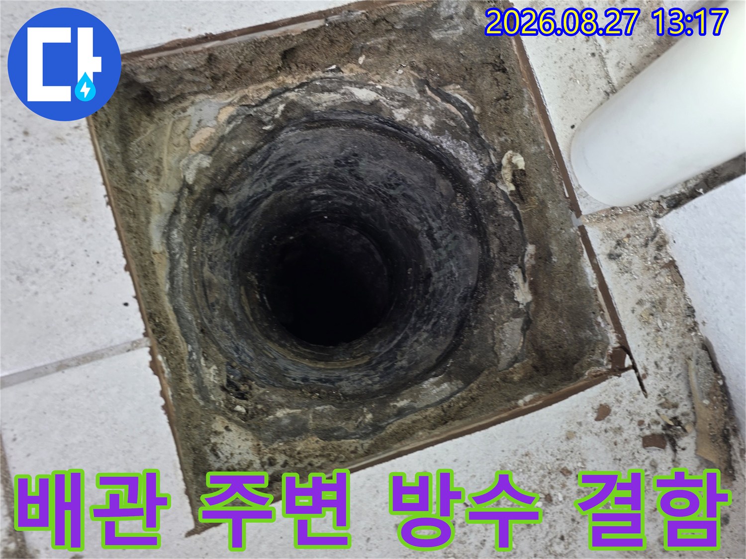 우수관 하단부의 젖은 타일과 오염된 배관 연결 부위 촬영